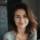 Femme souriante en intérieur, lumière naturelle.