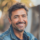 Homme souriant en plein air, portant une veste.